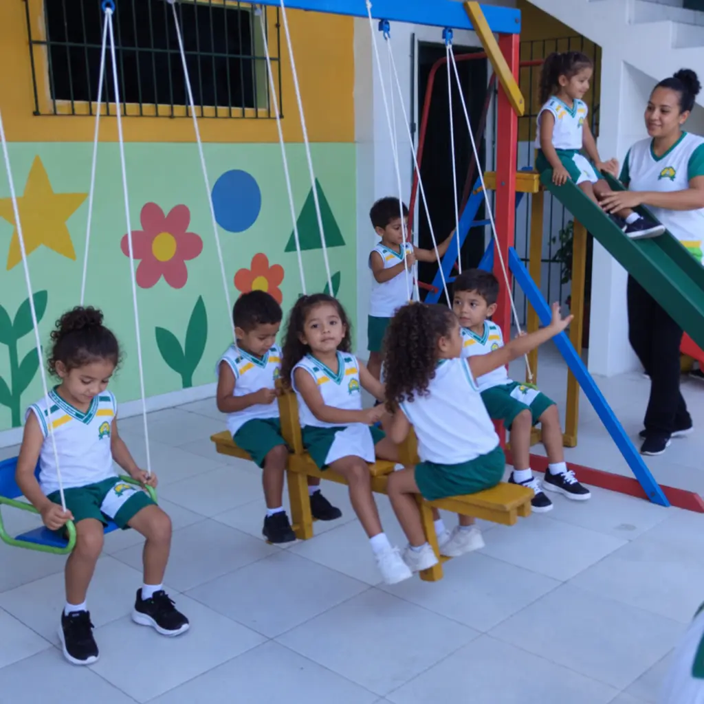 Crianças da Educação Infantil brincando no balanço do pátio